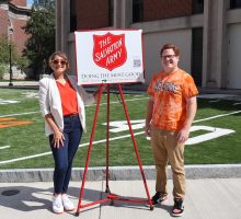 Office of Community Engagement Staff standing next to a Salvation Army Sign